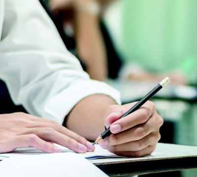 Photo of a person writing on a piece of paper on a desk